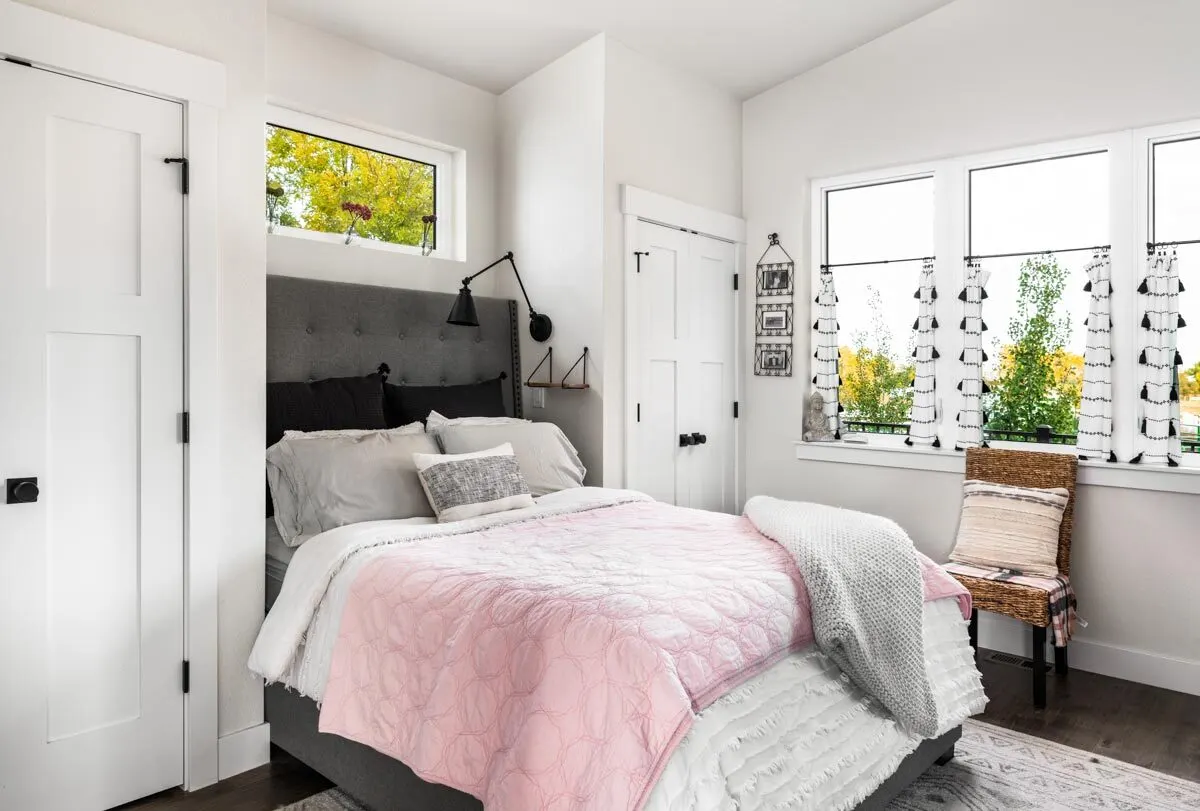 The bedroom appears comfortable in a modern style with a splash of pink hue.