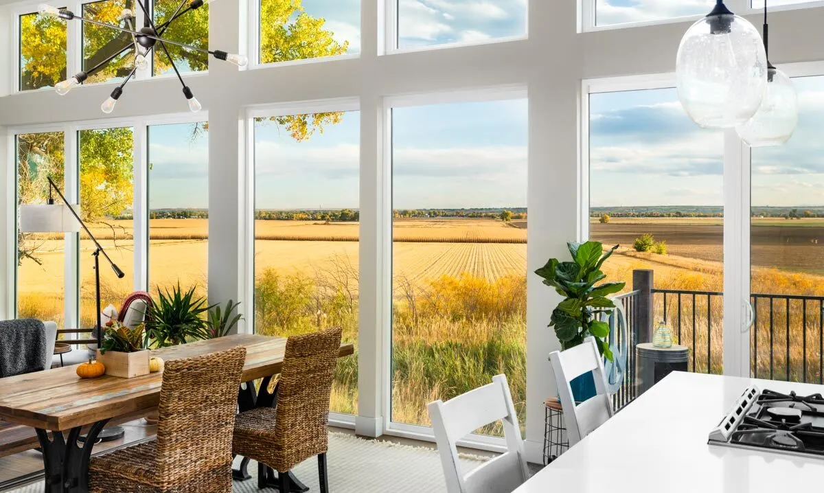 Large vertical windows in the house add to the ambiance of the outdoor view.
