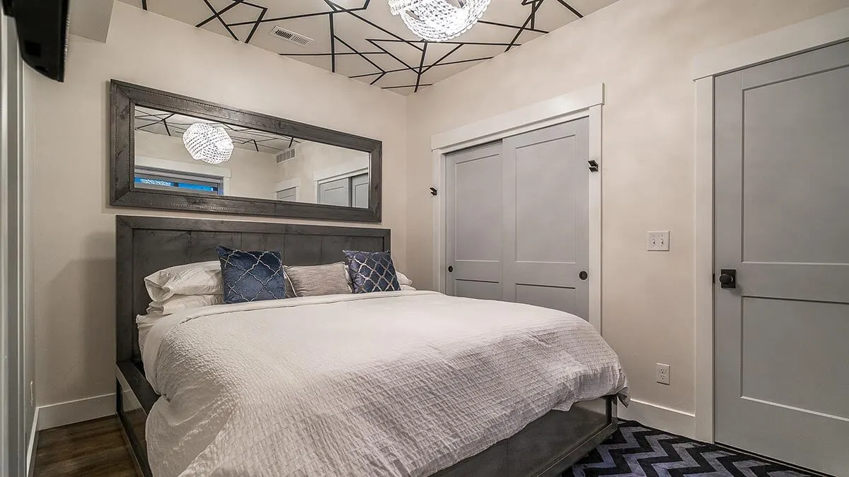 The bedroom, which has a large bed and a sliding wooden door on the side, appears to be comfortable.