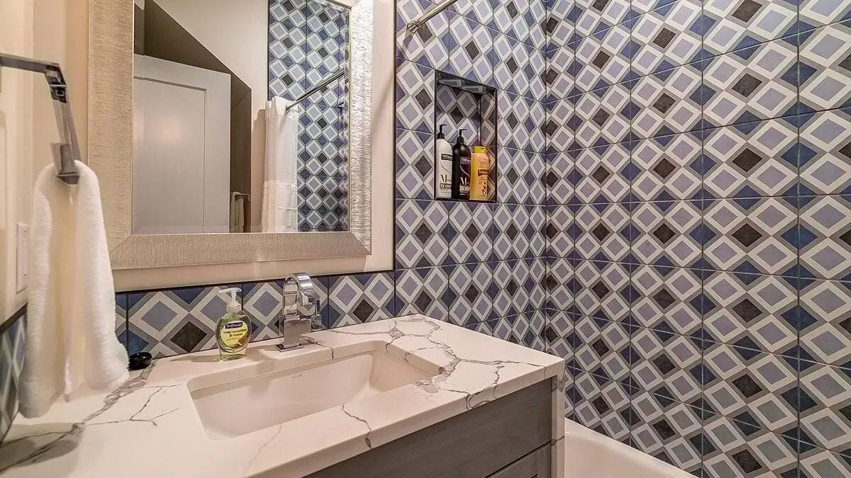 Bathroom with a sink and an exquisite blue wall tile pattern.