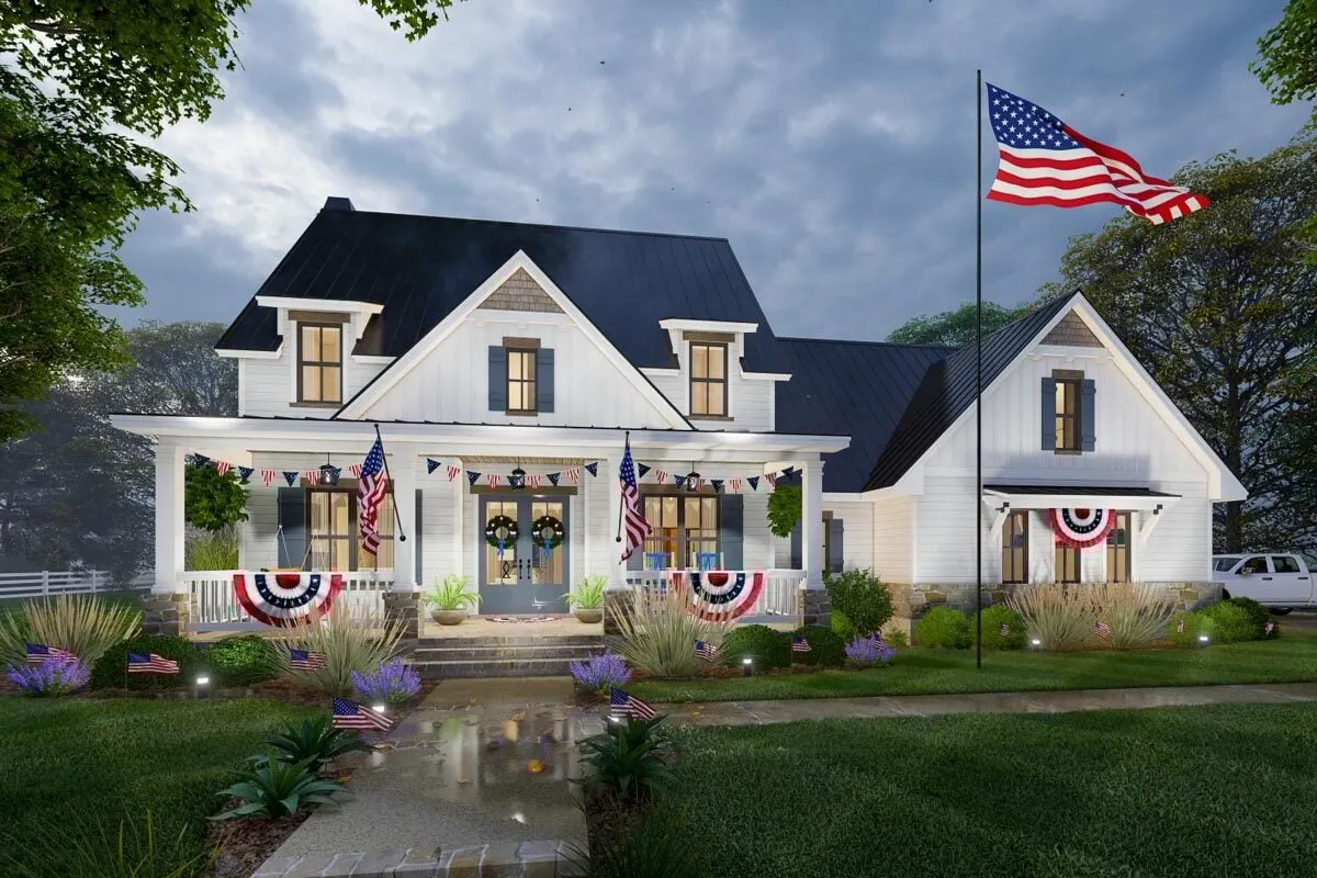 The modern farmhouse at night looks stunning while displaying the flags.