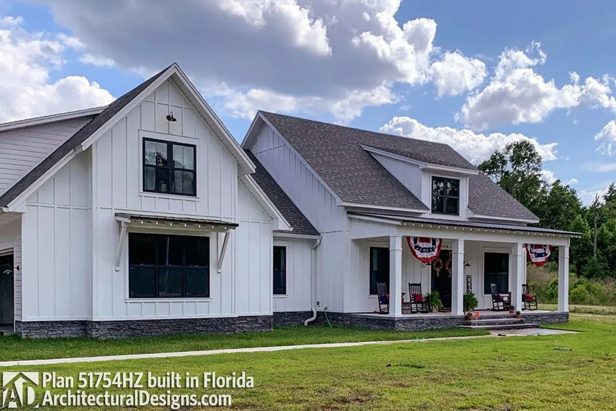 The view from the side of the modern farmhouse highlights the bonus room with a roofed window and main entry porch.