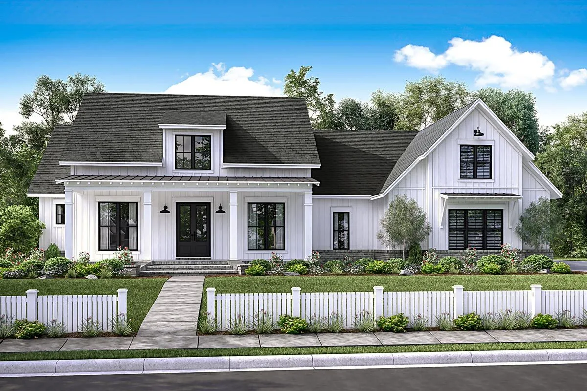 The white modern farmhouse with the classic-feeling front porch, stone pavement, and white wooden fence.