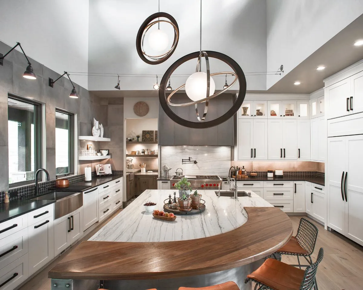 The kitchen island has a gray marble top down a wooden arch on the side.