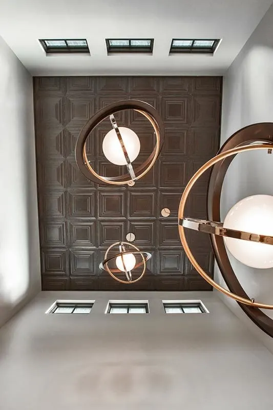 An exquisite globe light fixture suspended from a wooden box ceiling.
