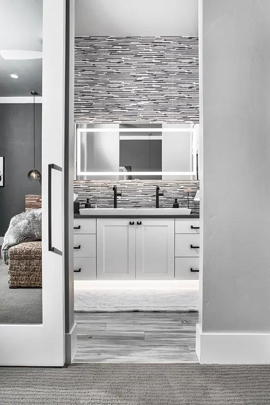 Bathroom with a black and white interior with a gorgeous backsplash.