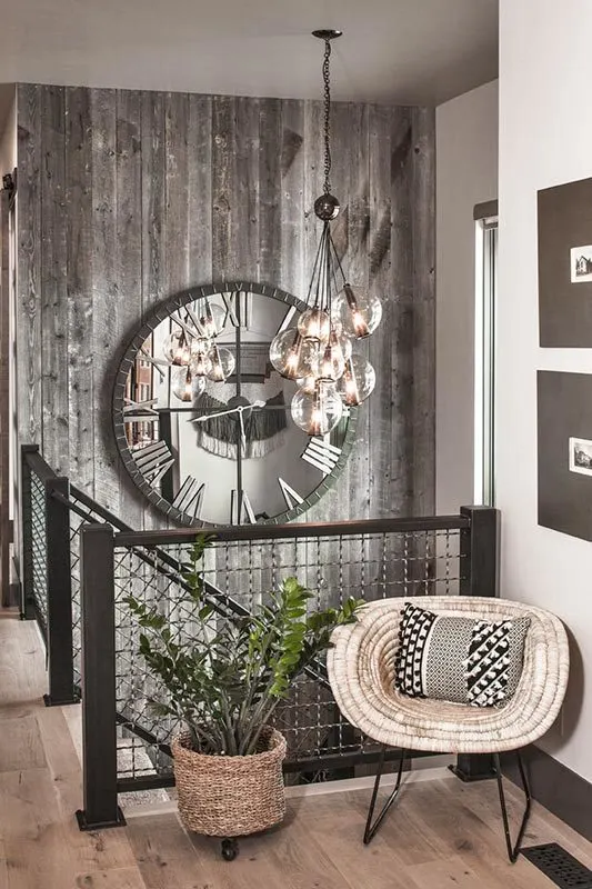 The foyer features an artsy bench in the corner and a massive black clock wall beside the stairs.