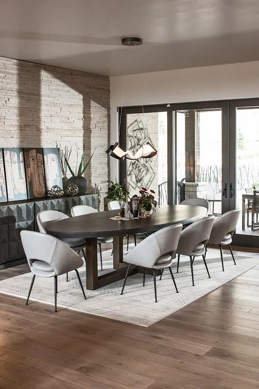 Dining room with a black table and gray leathered chairs.