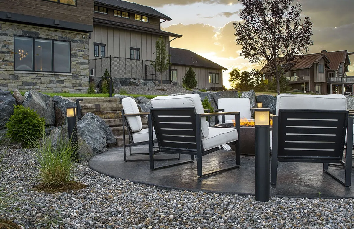 A stone yard surrounds the black and white lounge chairs.