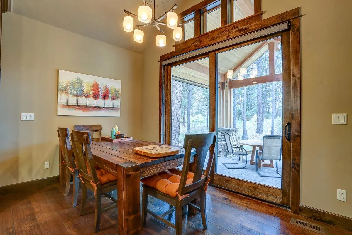 The dining room includes a wooden table and chairs with orange cushions.