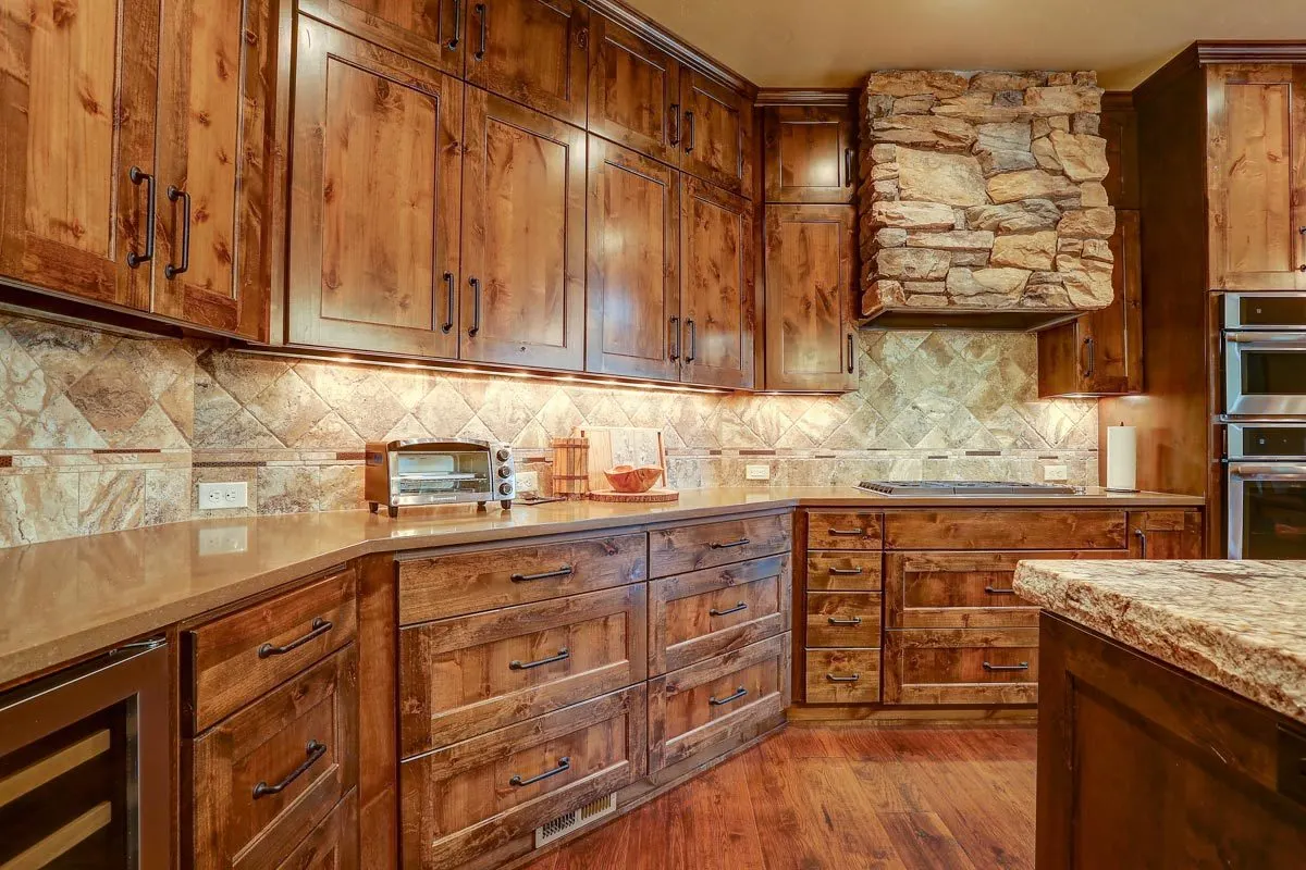 The kitchen's interior with its wooden and stone accents has an extravagant appearance.