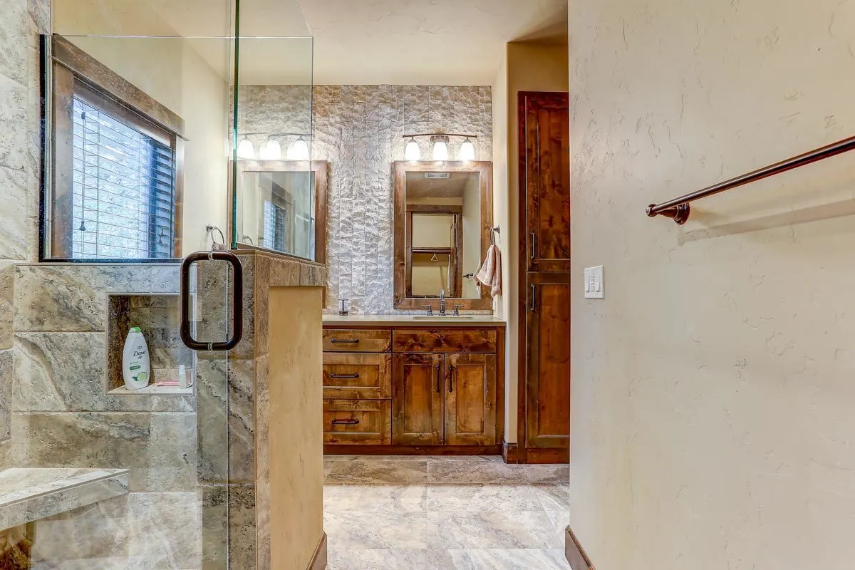 Shower room with a stone wall and glass doors.