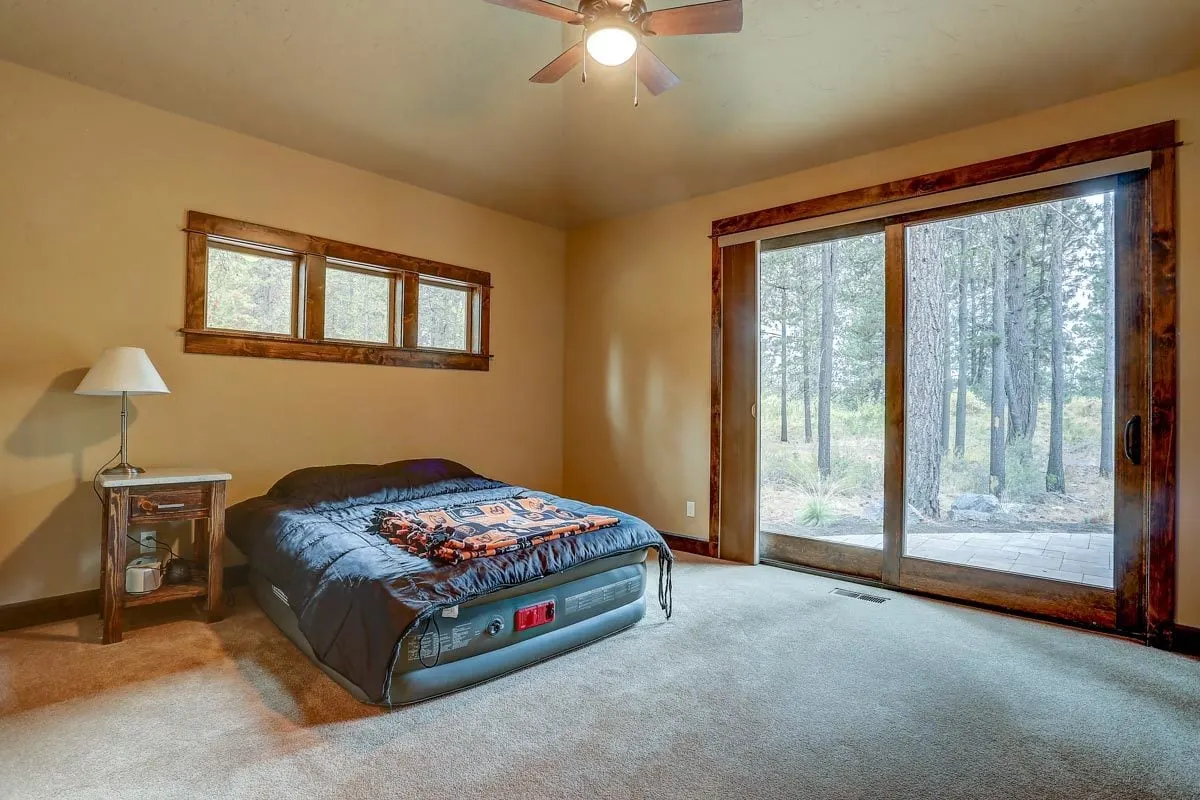 Inflatable mattress in the bedroom area with a view of the outside through a big glass sliding door.