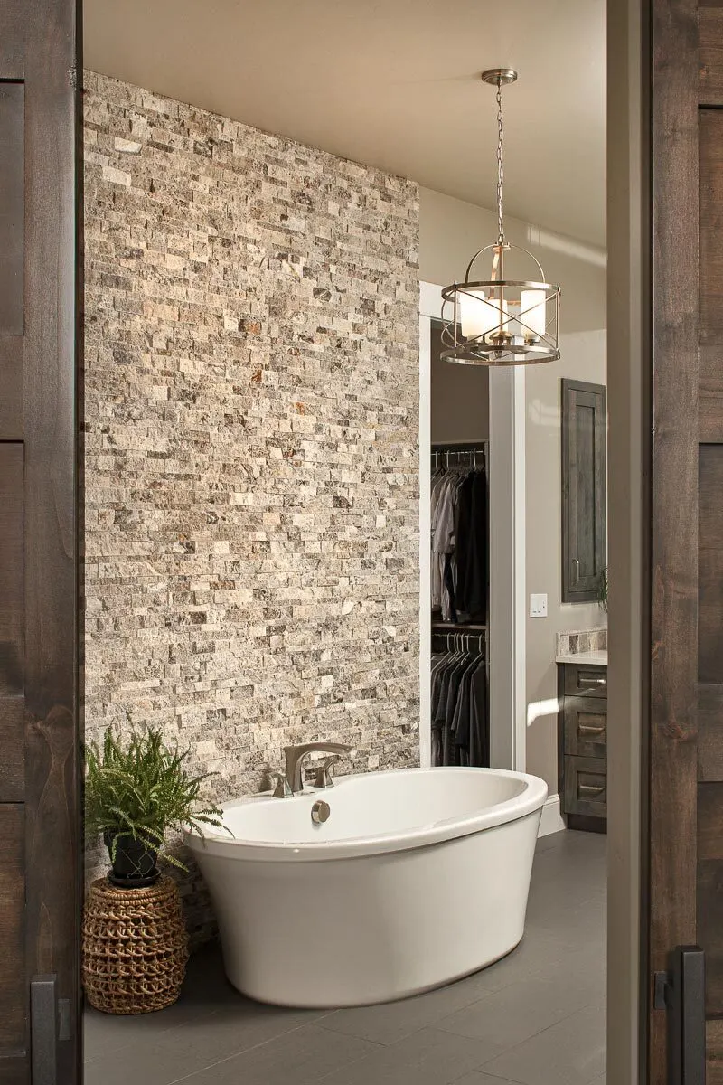Behind the bathroom is a closet with a stone brick wall design.