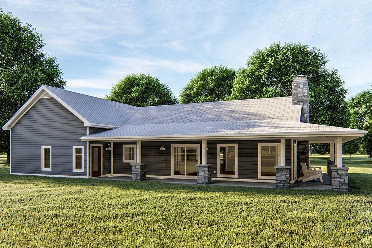 A view on the side of the barndominium that focuses on the expansive grasslands and the porch that wraps around the house.