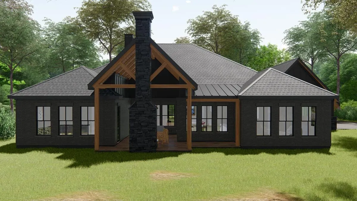 The back of the home seems lovely in dark tones, with glass windows and a stone chimney.