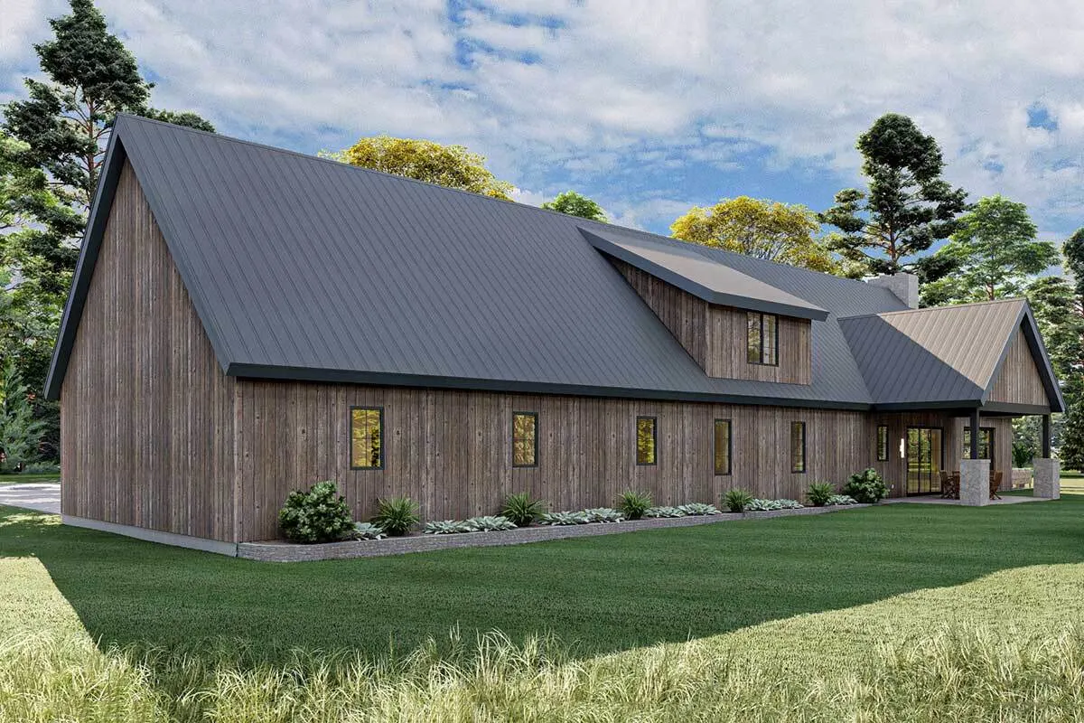 A viewpoint of the back of the barndominium, which reveals the uniquely designed façade of the home as well as a considerable quantity of grasslands.