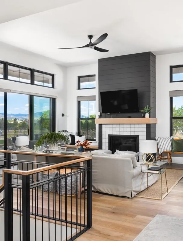 A spacious area of the living room with large glass windows and a fireplace in the center
