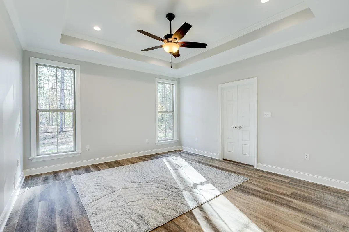 The master bedroom has a view of the outdoors thanks to the huge windows.
