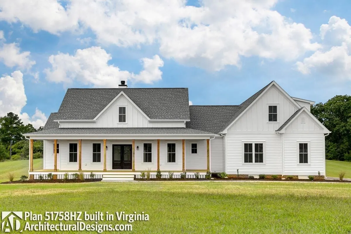 The spacious and modern farmhouse with the light gray roof, the white walls, and the wooden frame post.