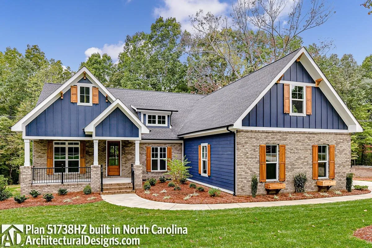 Dark blue craftsman siding and wooden accent shutters look good together.