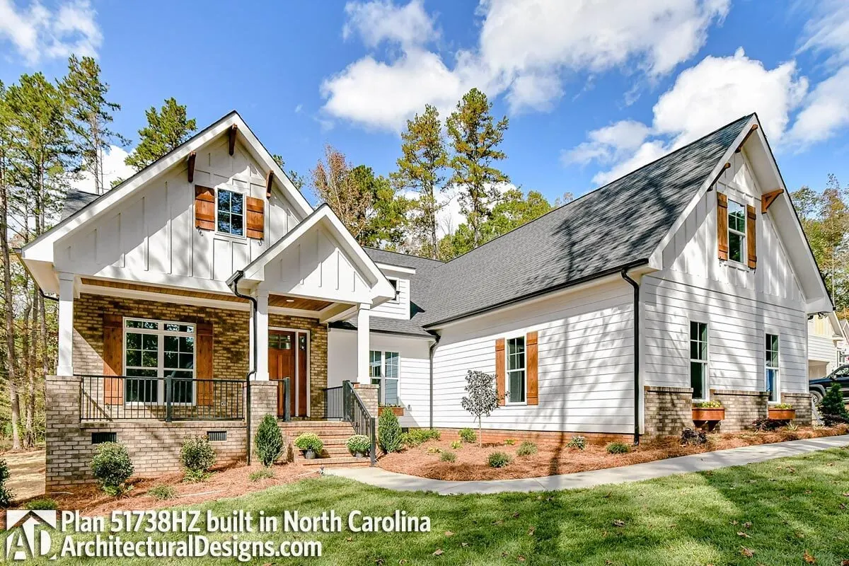 Craftsman-style exterior in black and white with a brick accent wall on the porch.