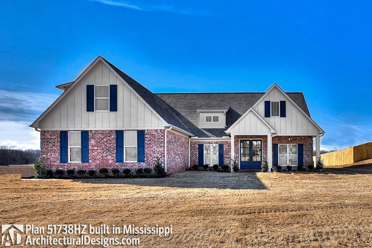 The use of blue in the entrance and shutters makes the house's exterior stand out.