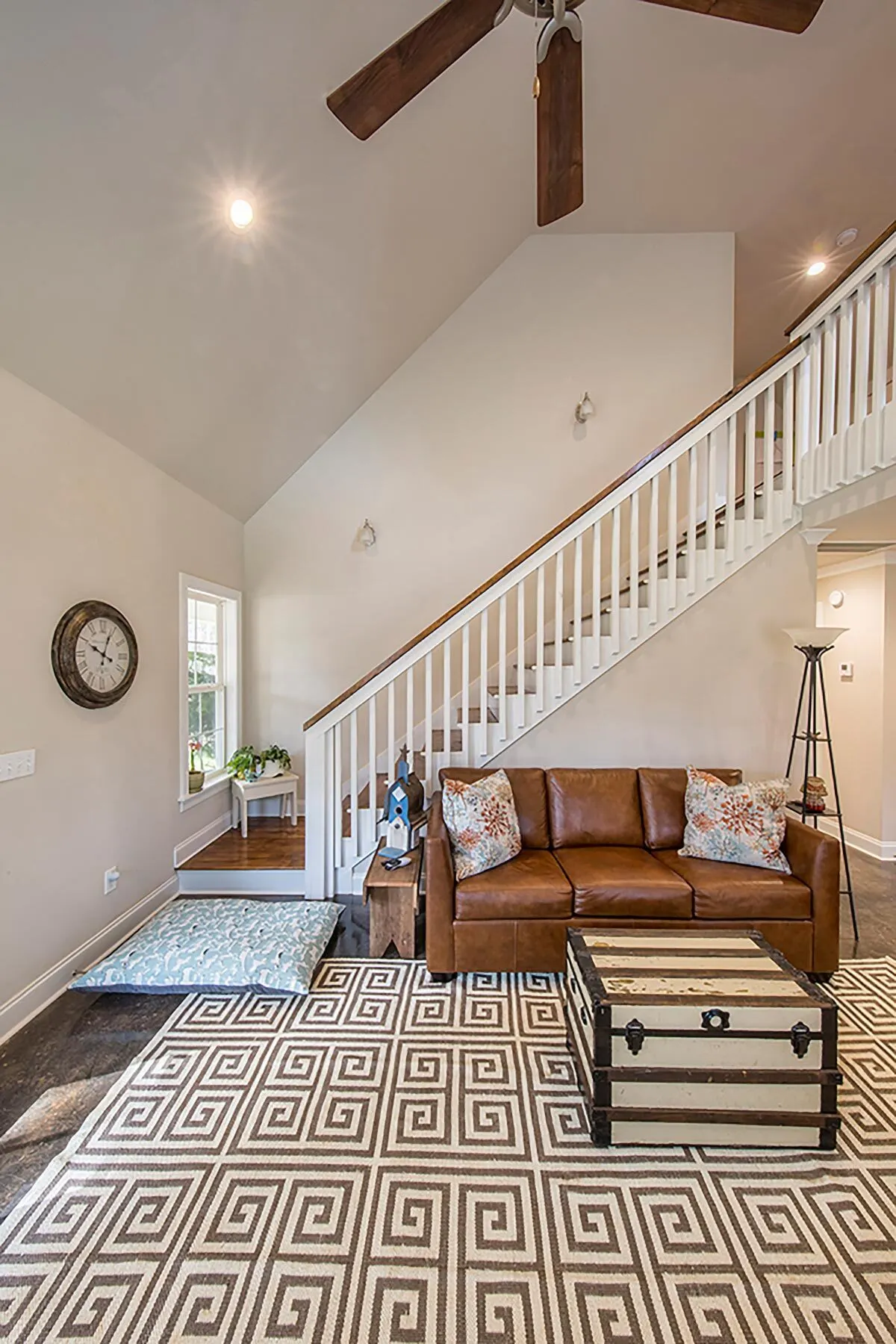 A lovely brown leather sofa under the stairway in a wooden accent.