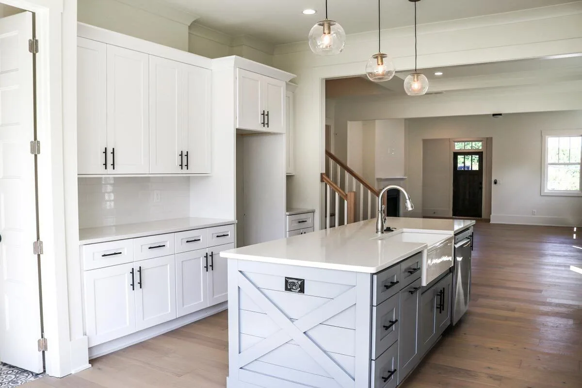 The kitchen island has a gray-painted base with a white countertop.