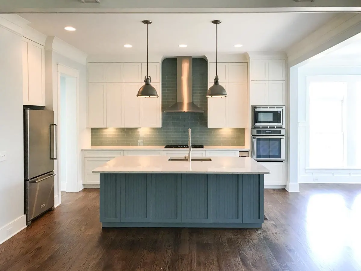 The high ceiling is noticeable in the kitchen area, which also has handy cabinets.