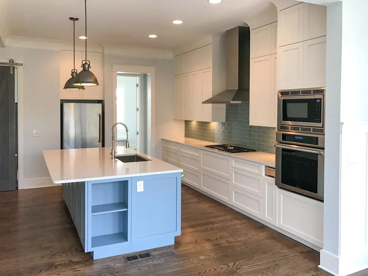 The beautiful green backsplash complements the white counter and cabinetry.