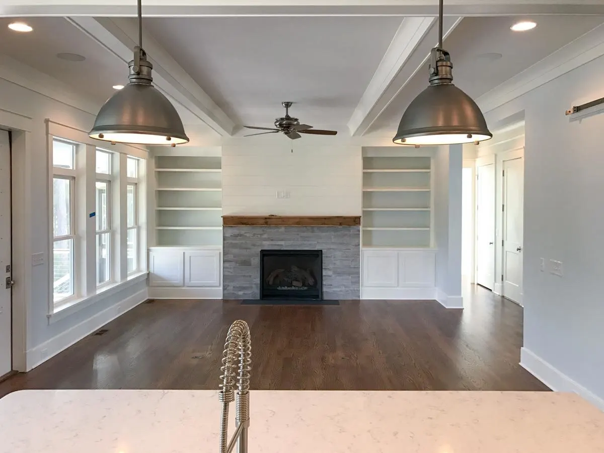 A metallic lighting fixture matches the ceiling fan in the living room.