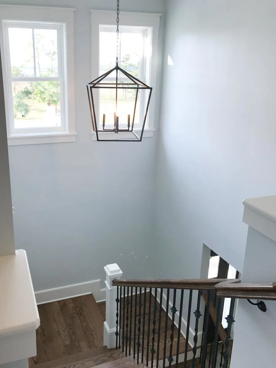 The staircase has a wood accent and a black metal railing.