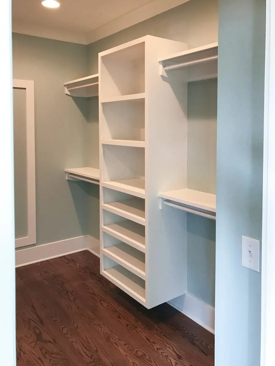 The dim lighting in the closet complements the blue wall color well.
