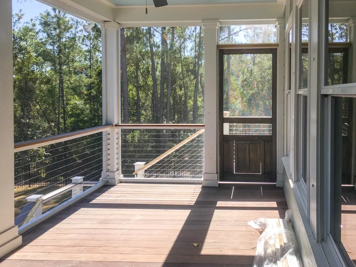 A classic screened porch with aluminum frame windows and wood floors.