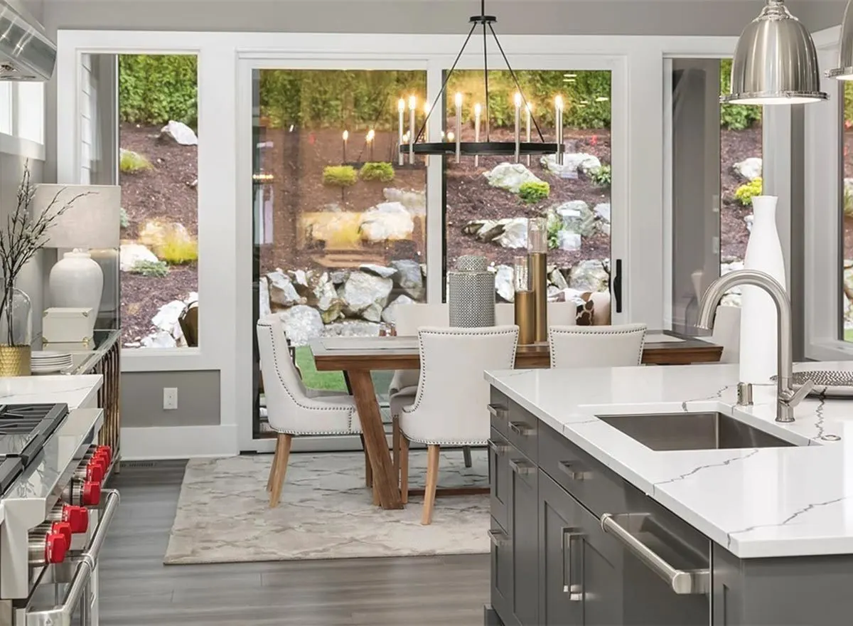 Dining nook with a beautiful wood table set beneath a candle chandelier.