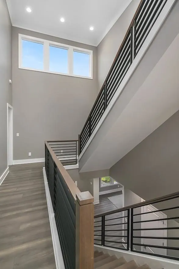 The stair was made of black metal fencing with wood handrails.