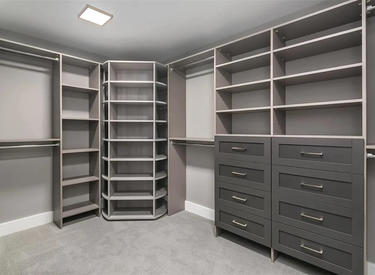 Wall-mounted gray shelves and racks in a walk-in closet.