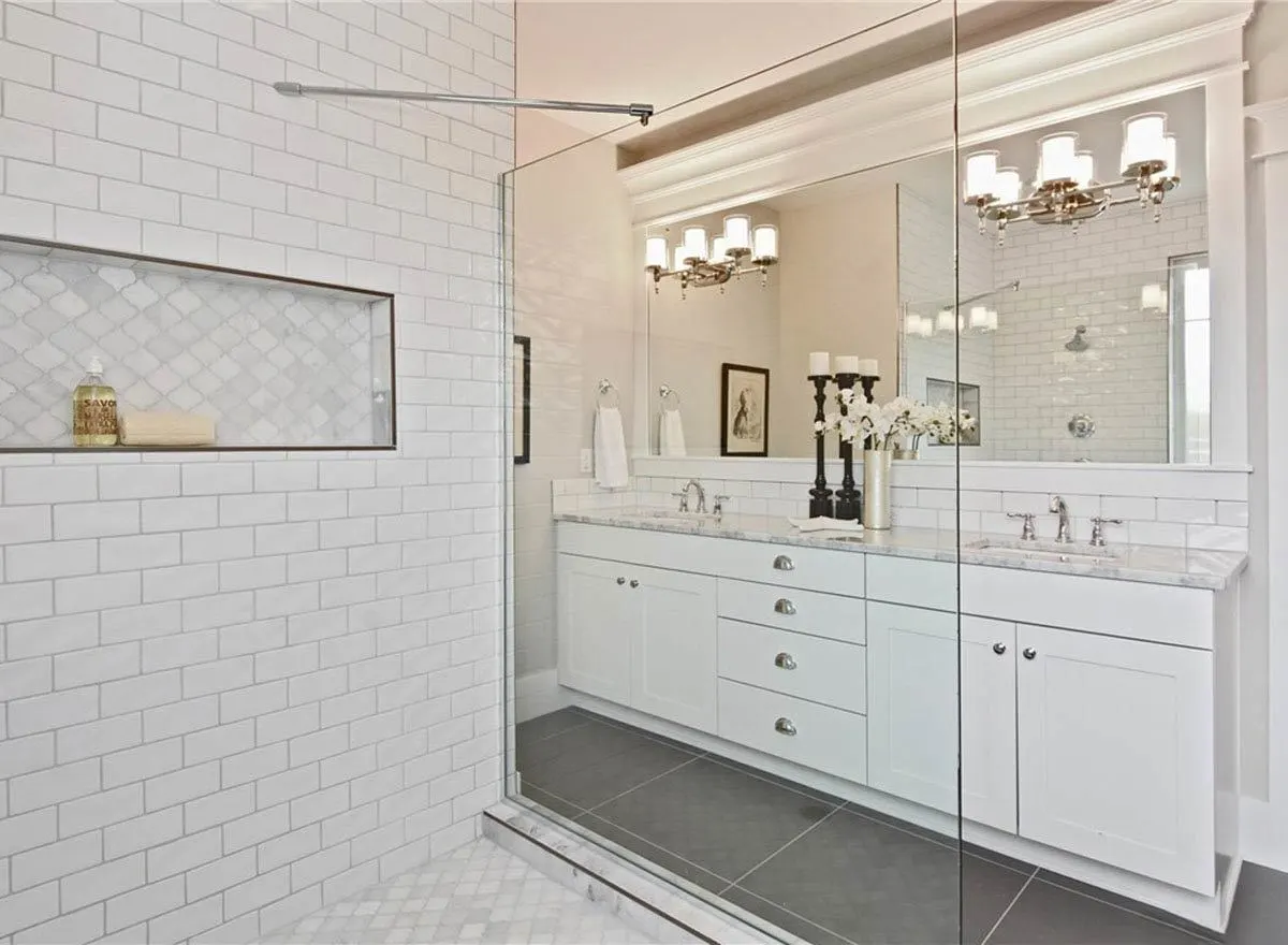 A look of the inside of the glass bathroom showing the elegant design on the countertop and lights.