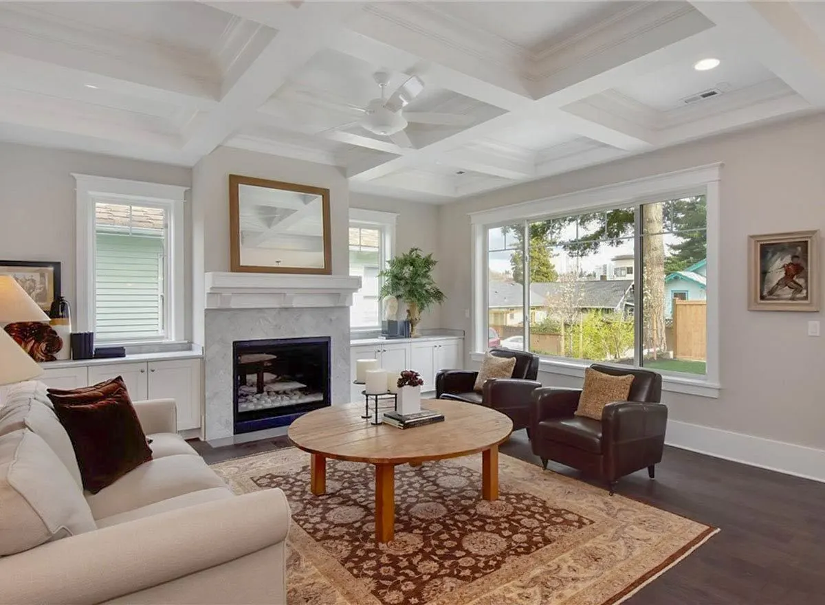 The living room with a huge glass window. and two small window beside the fireplace and an amazing design of the ceiling.