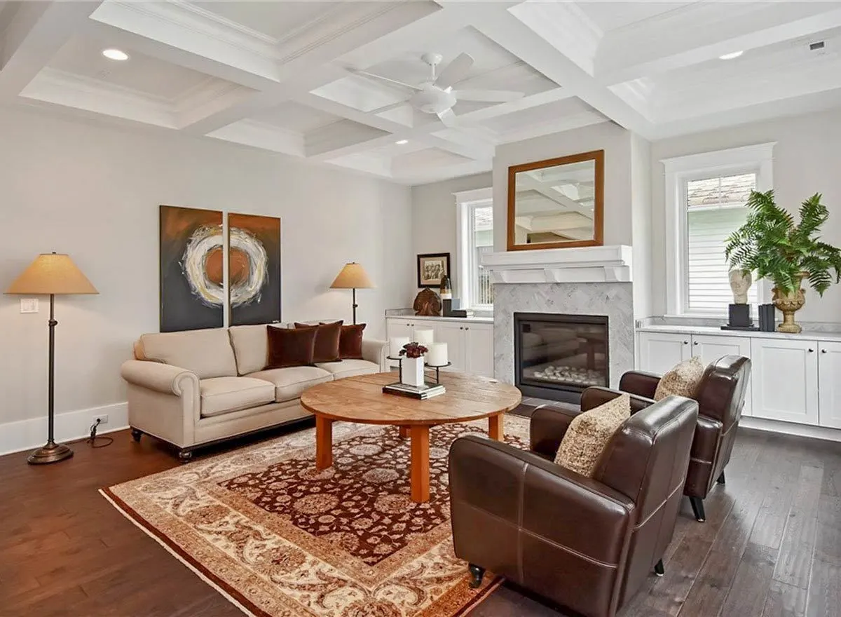 Another view of the living room area showcasing the beauty of the ceiling along with the countertops beside the fireplace.