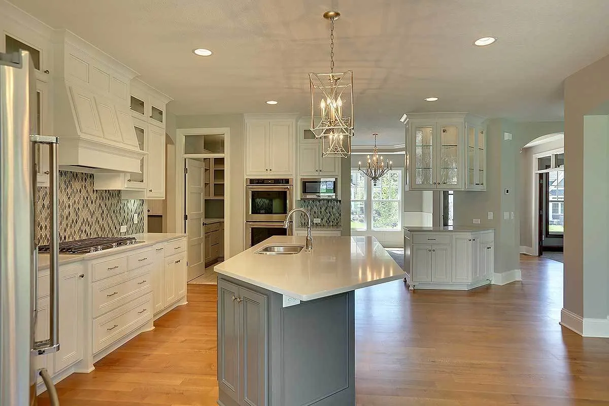 A wide view of the kitchen area showing the beautiful kitchen island as well as the artistic designs of the lamps.