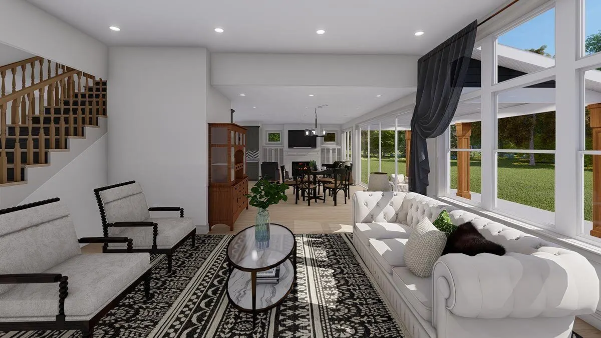 A center table made of oval glass is paired with a stylish white sofa and seats.