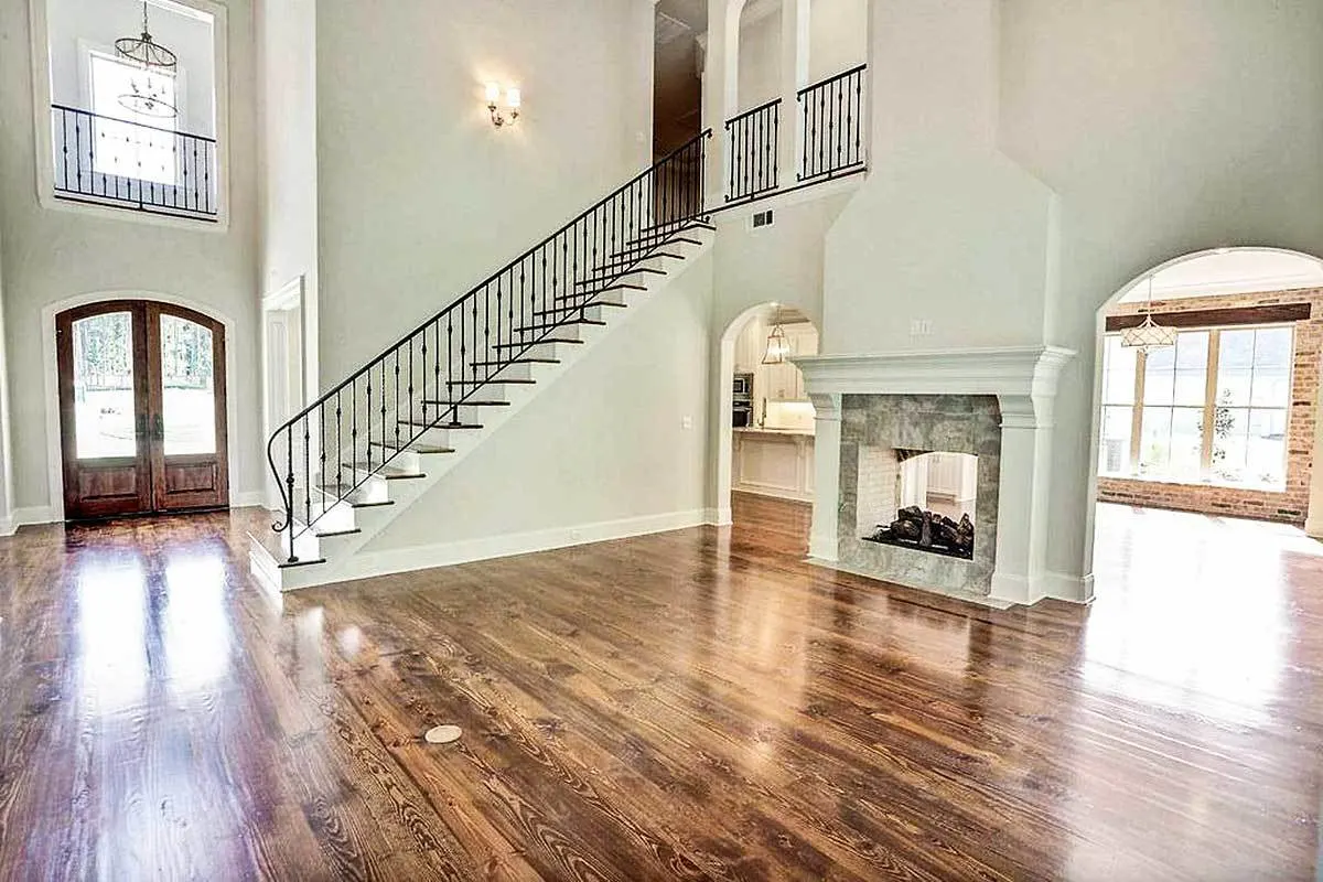 A large great room with a stone-framed fireplace.
