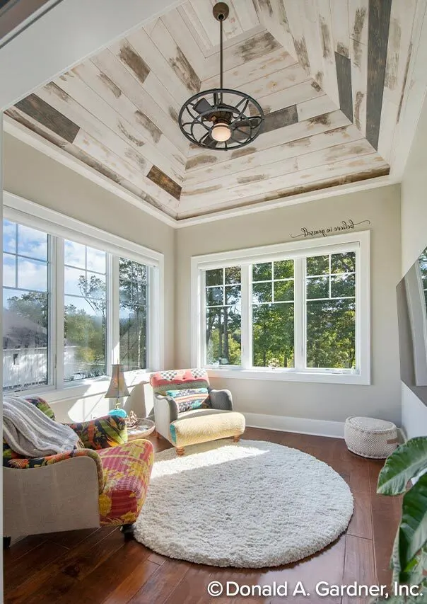 The sunroom space has colorful design sofas and a high ceiling feature.