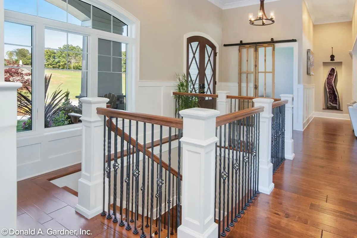 Stairs installed wood accent handrail and black metal fence.