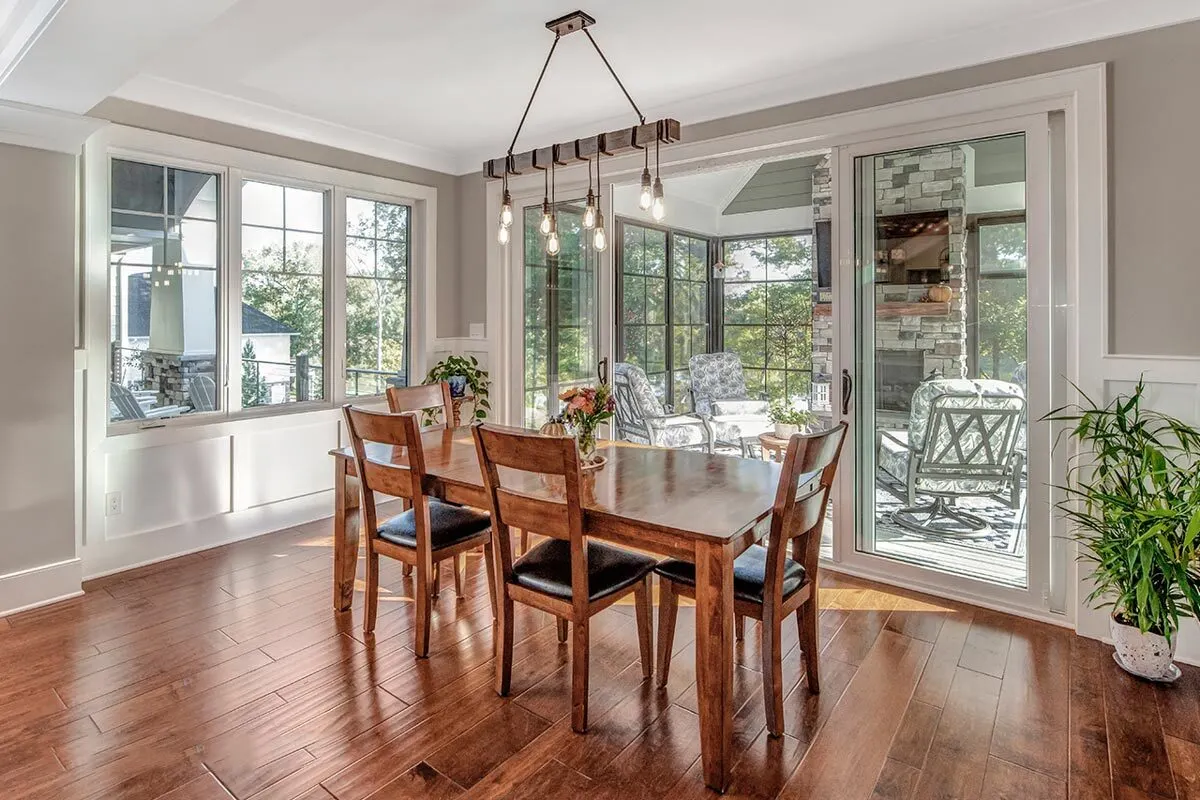 Breakfast nook with a strong stylish dining table made of wood that complements the floor.