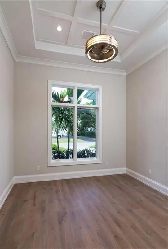 A modest room with beige walls and a beautiful chandelier overhead.