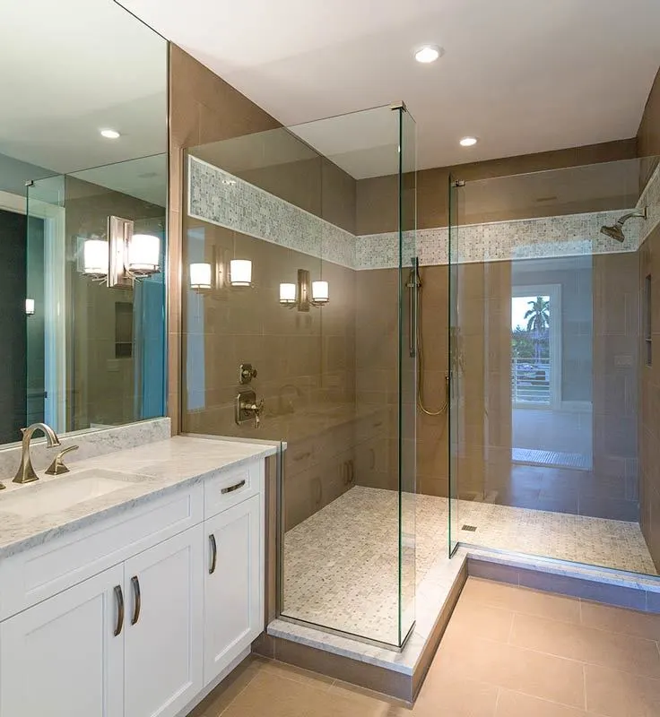 Master bathroom with an L-shaped shower with a tiled floor and glass framing.
