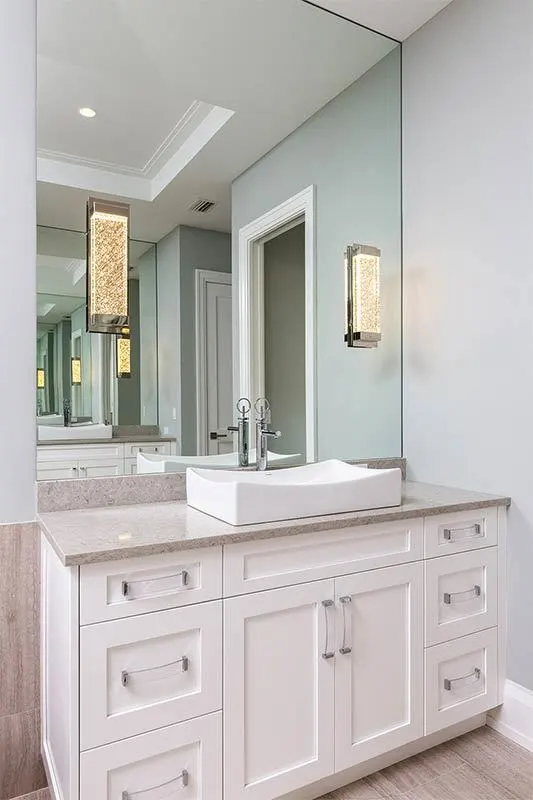 Vanity area with white cabinet and neutral marble color countertop.